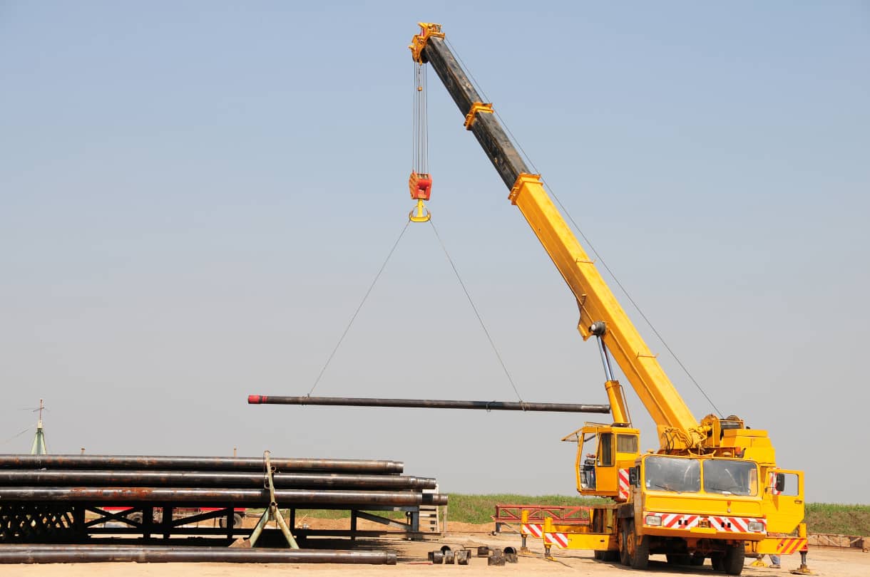 a large crane lifting piping using vehicle stability tracking